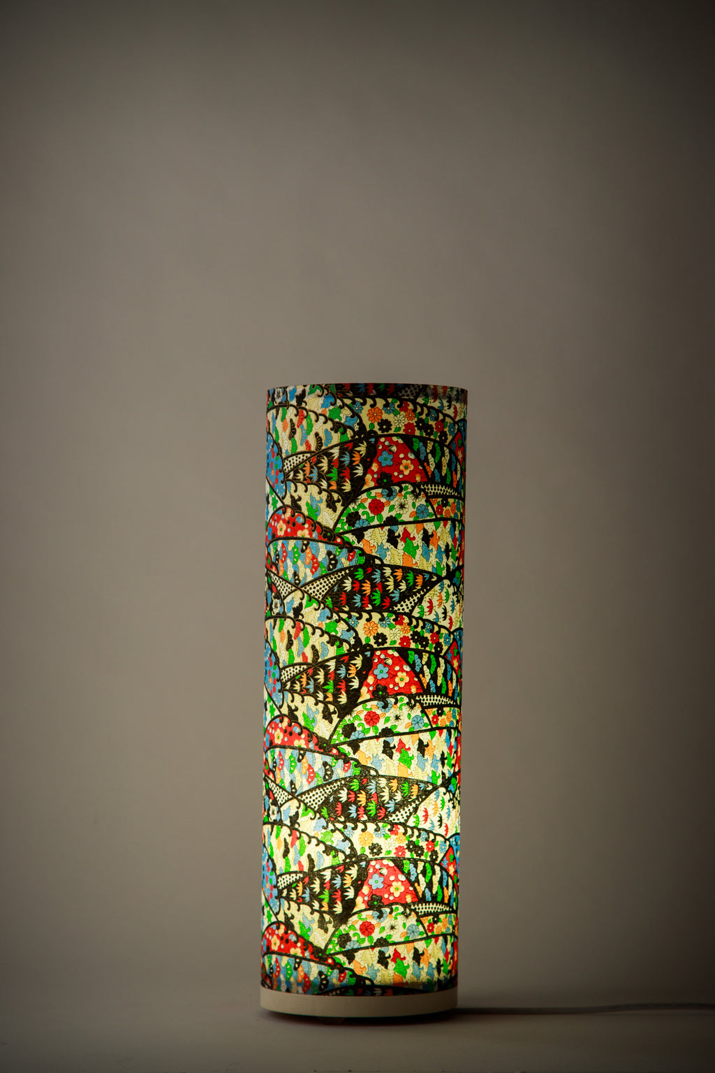 Studio design colorful festival table lamp illuminated, highlighting layered arc patterns and warm ambient light