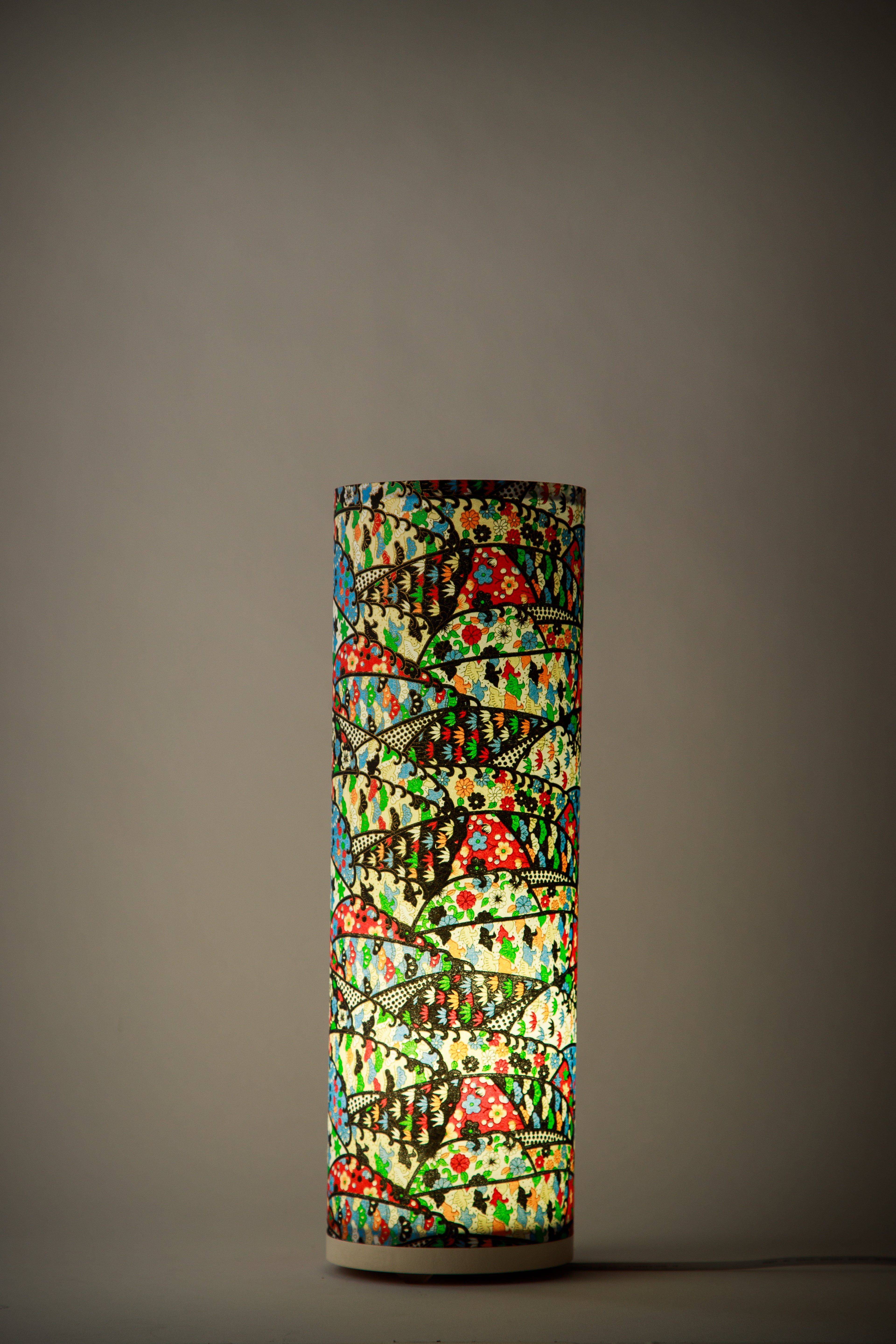 Studio design colorful festival table lamp illuminated, highlighting layered arc patterns and warm ambient light