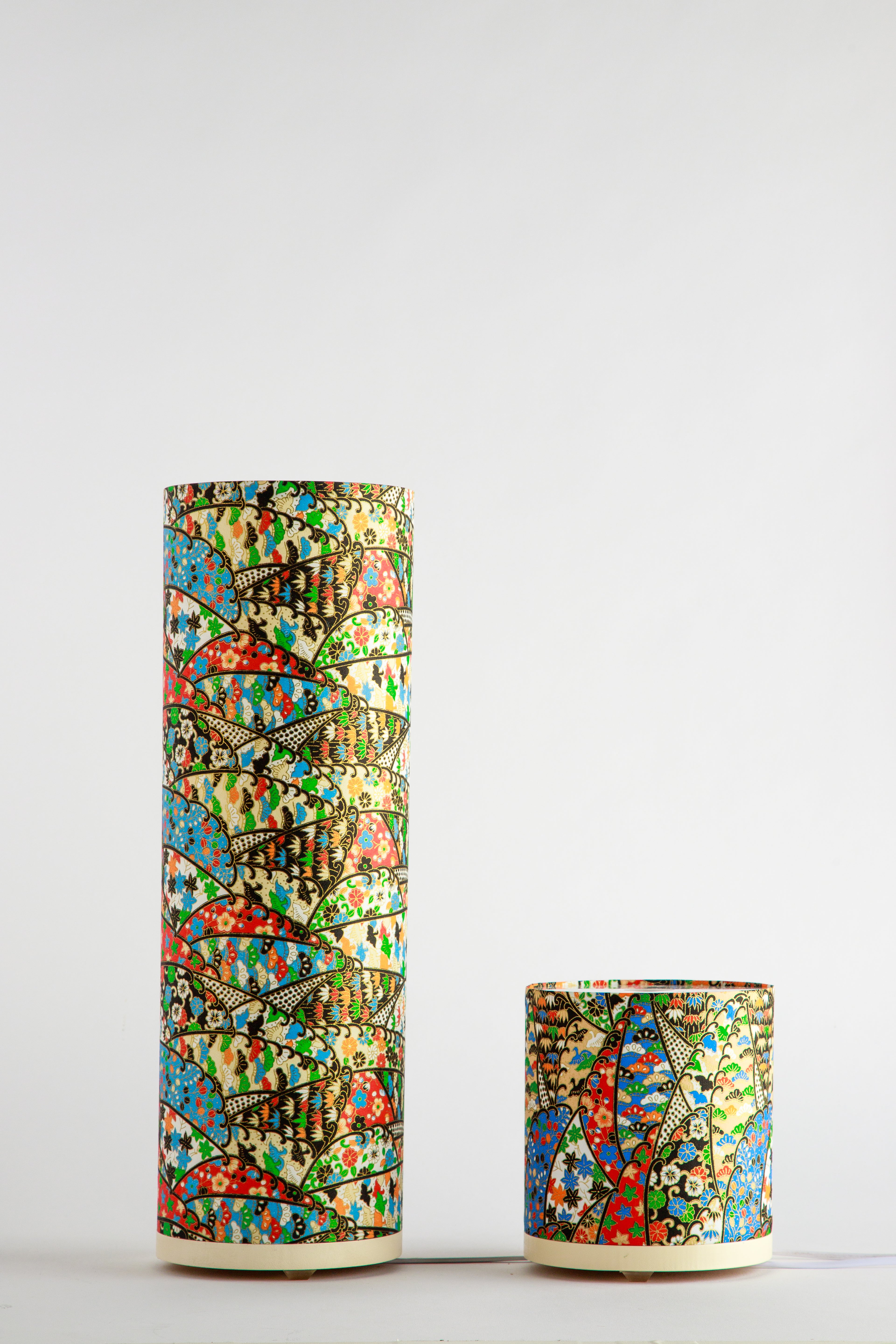 Branstead Design canvas table lamps in tall and short sizes, unlit, showing colorful festival rhythmic fan-patterned textile design