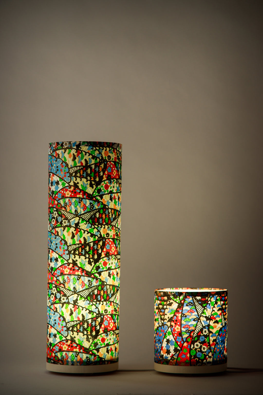 Branstead Design custom-made canvas lamps lit, made of Japanese paper, casting a warm glow through repeating geometric fan motifs