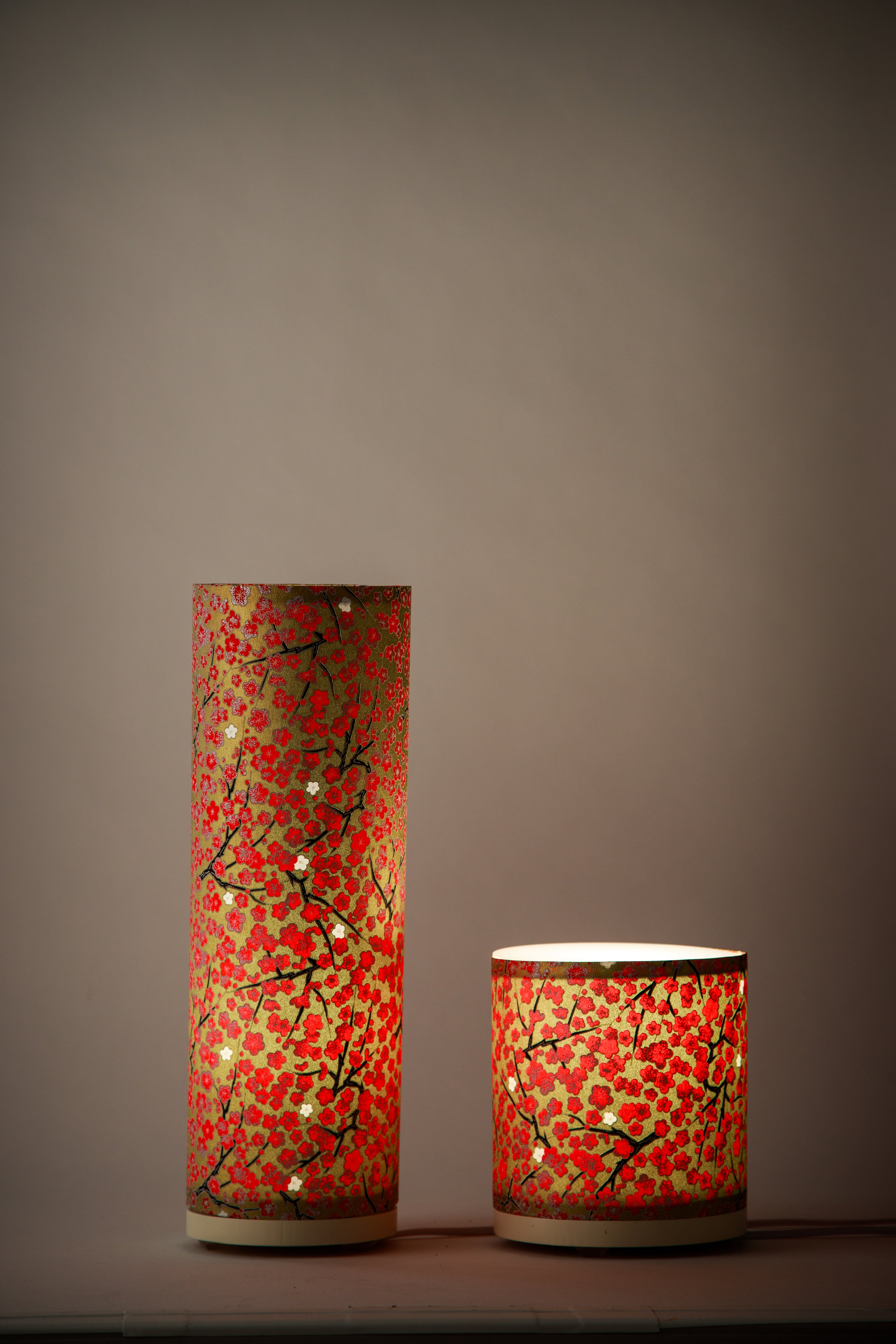 Two cylindrical decorative nightstand lamps with Japanese Cherry Blossom floral patterns on a golden tree background