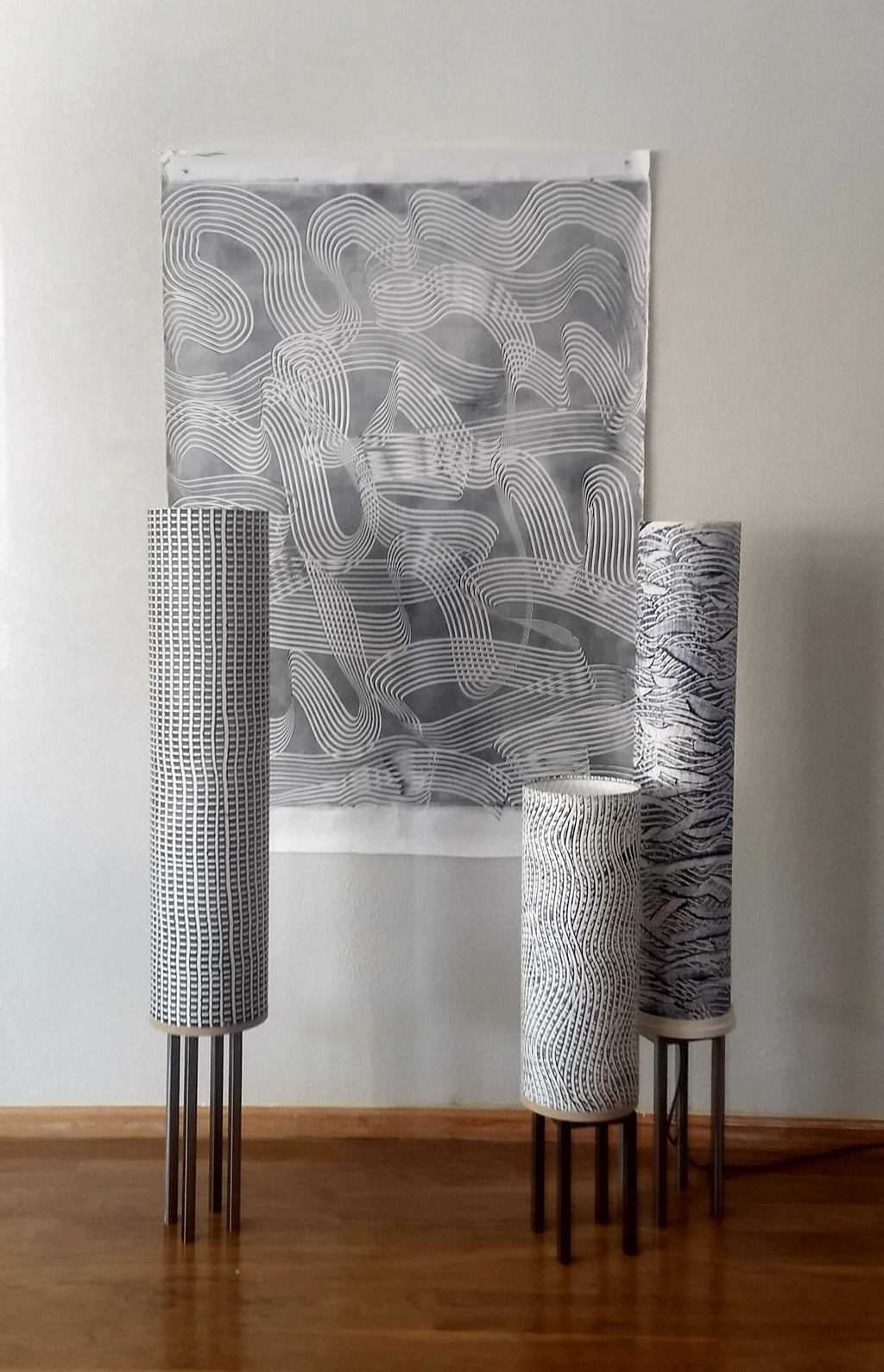 Beautiful custom-made grey floor lamps by Patricia Branstead arranged with abstract gray artwork.