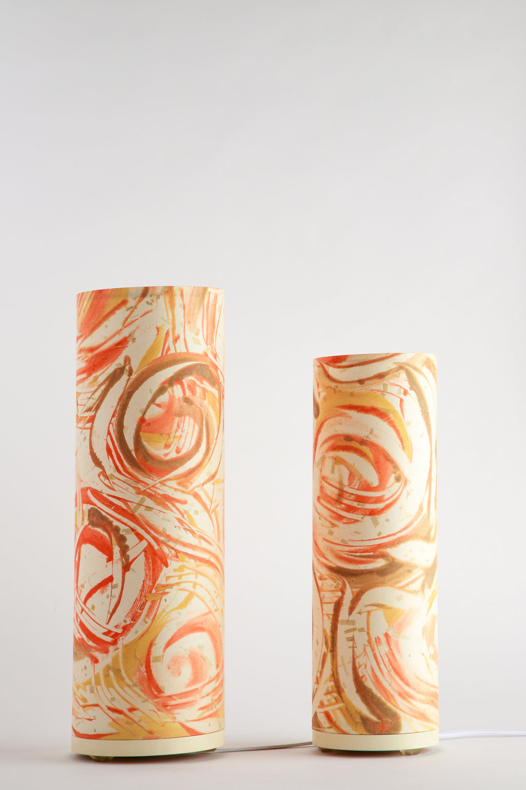 Hand-painted canvas table lamp with swirling rust, amber, and cream tones on a white background