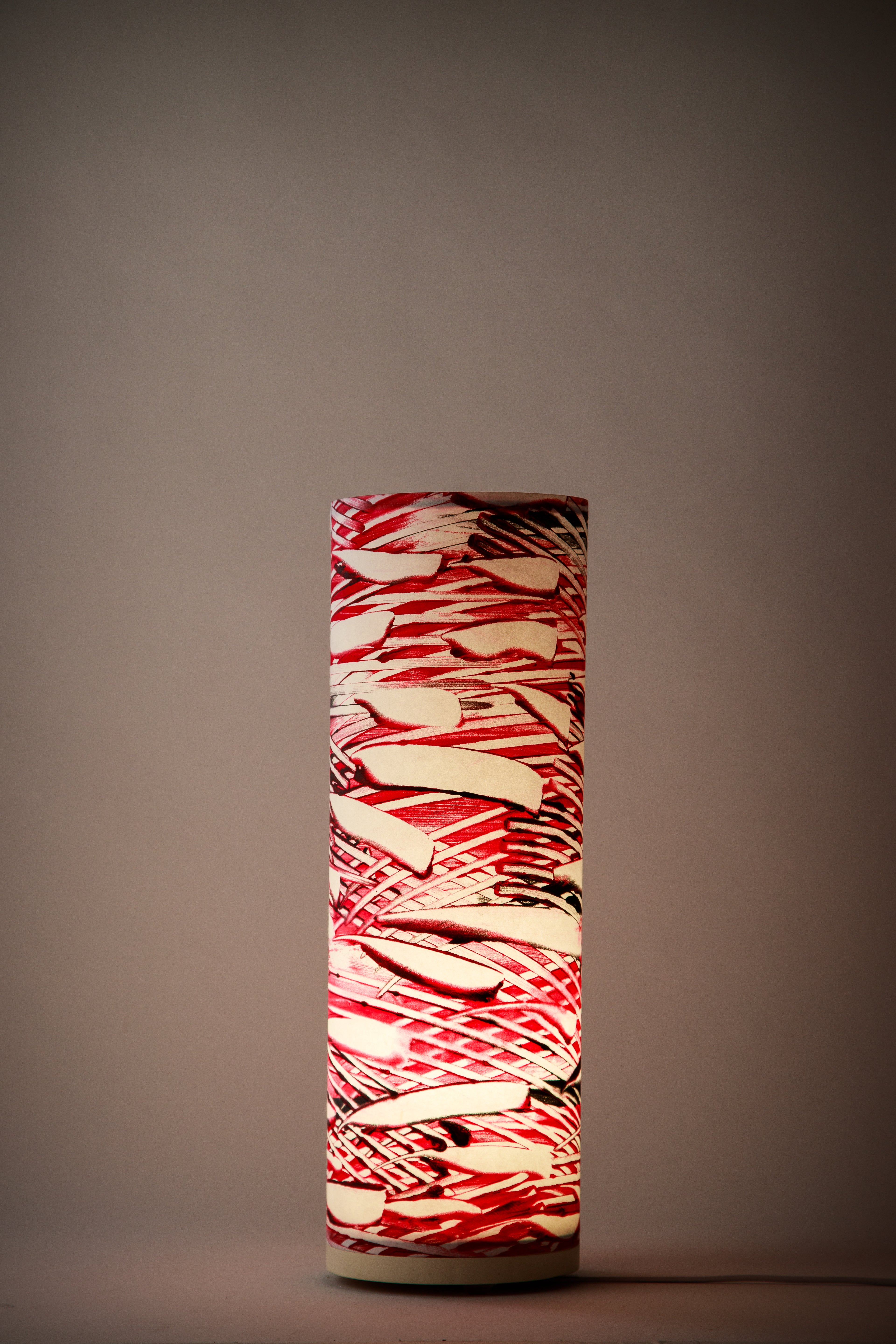 Strata – Crimson Samurai artist-made canvas table lamp by Patricia Branstead illuminated in a dim room, casting a warm ambient glow through expressive red brushwork.