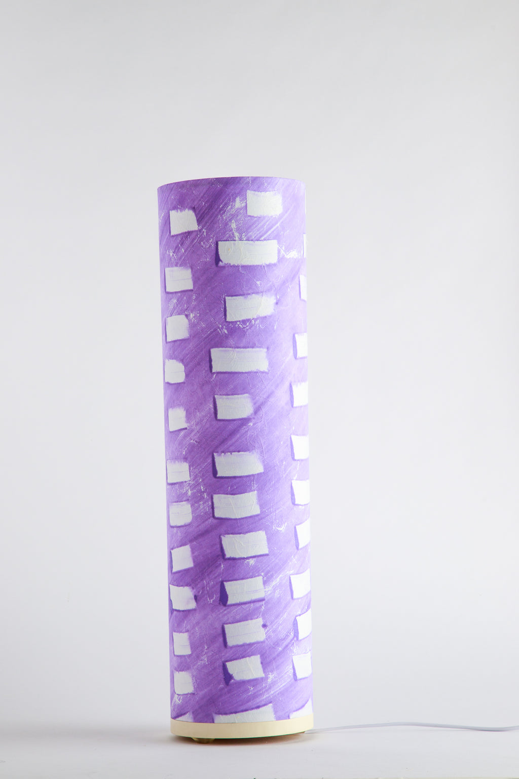 Purple canvas table lamp painted by artist Patricia Branstead with repeating white rectangular pattern on a clean white background