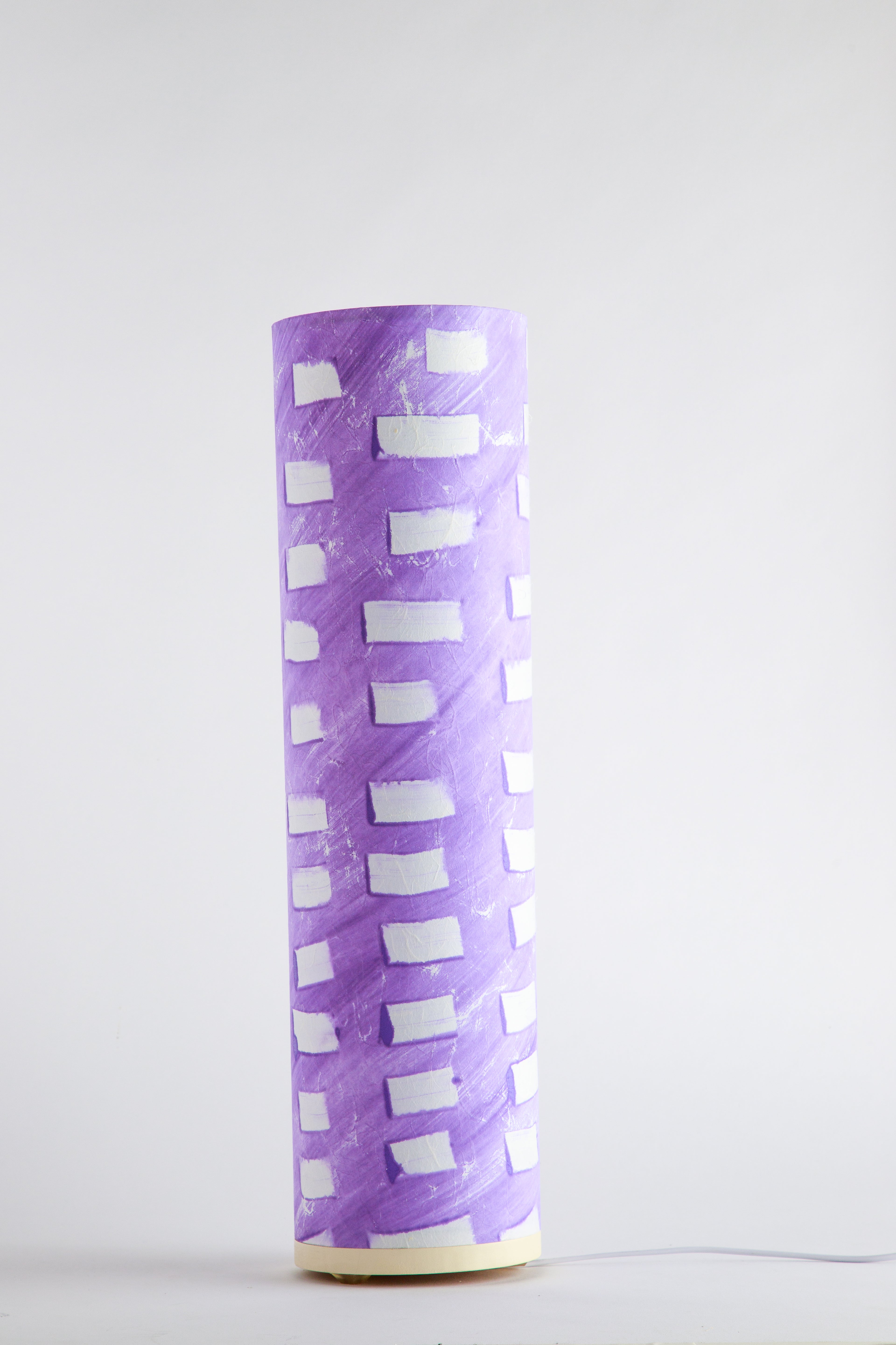 Purple canvas table lamp painted by artist Patricia Branstead with repeating white rectangular pattern on a clean white background